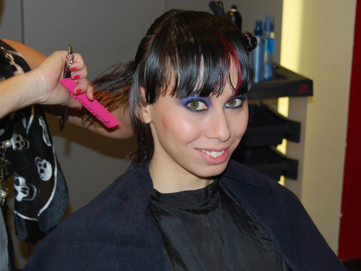 Lächelnde Hostess beim Styling im Friseurstuhl, fertig geschminkt und beim Haare machen, Vorbereitung für Event, Shooting und Promotion Einsatz