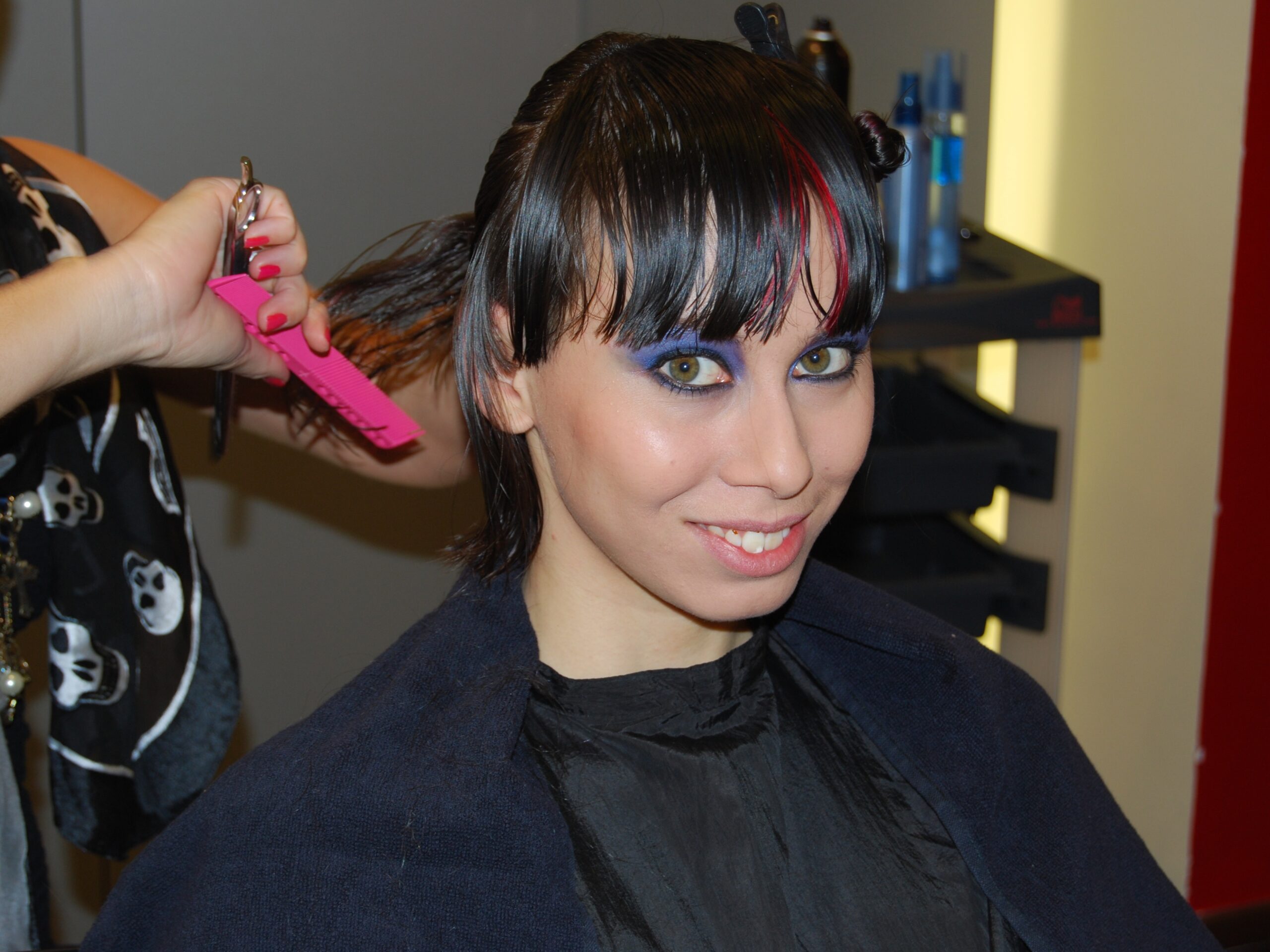 Lächelnde Hostess beim Styling im Friseurstuhl, fertig geschminkt und beim Haare machen, Vorbereitung für Event, Shooting und Promotion Einsatz