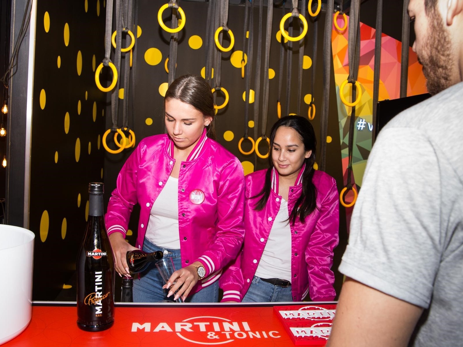 Zwei Frauen in pinken Jacken und weißen T-Shirts am Ausschank, freundlicher Service bei Event, Promotion und Catering Einsatz