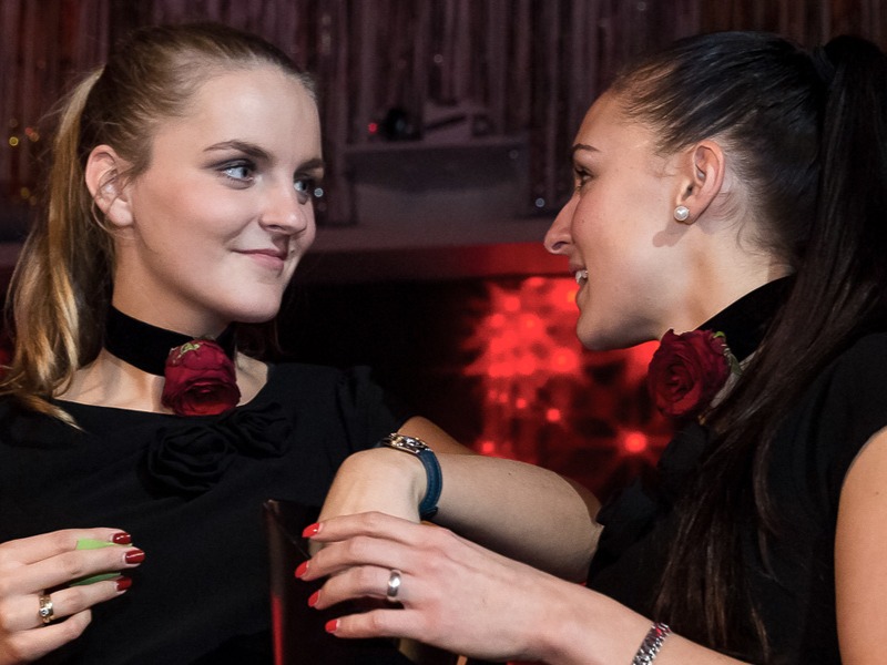 Zwei Hostessen in schwarzen Outfits mit Blumenketten um den Hals, stilvoller Empfang bei Event, Promotion und Hospitality Einsatz