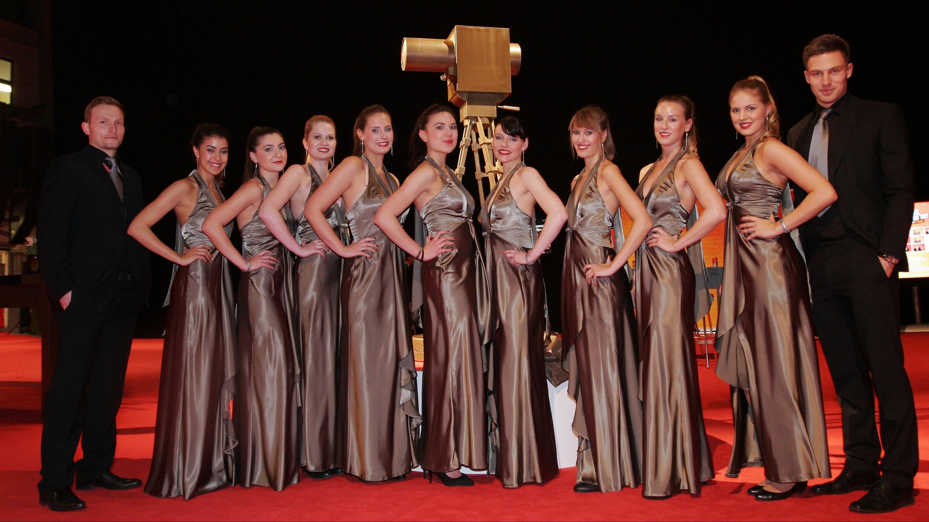 Mehrere Frauen in Abendkleidern vor der Goldenen Kamera, flankiert von zwei M&auml;nnern im Anzug, eleganter Empfang bei Gala und Event Veranstaltung