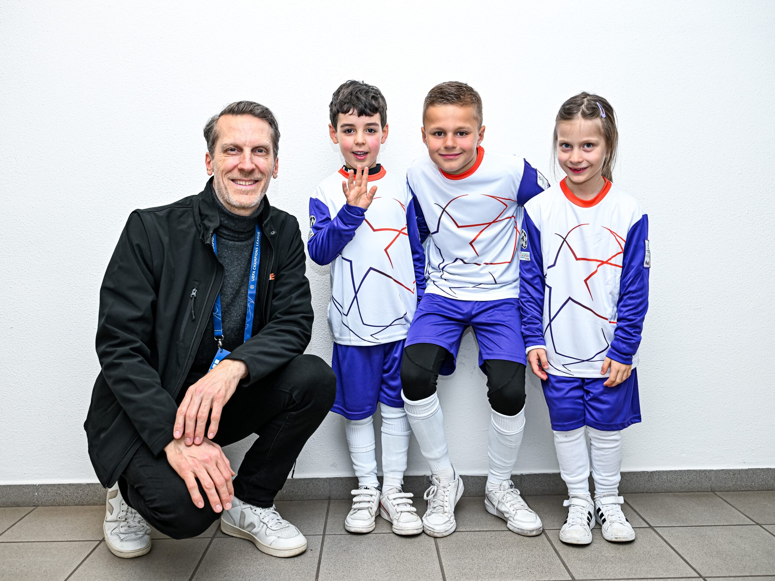 Drei Kinder mit einem Mann in Fußball-Outfits, sportliche Promotion Aktion bei Event, Verein und Markenaktivierung im Einsatz