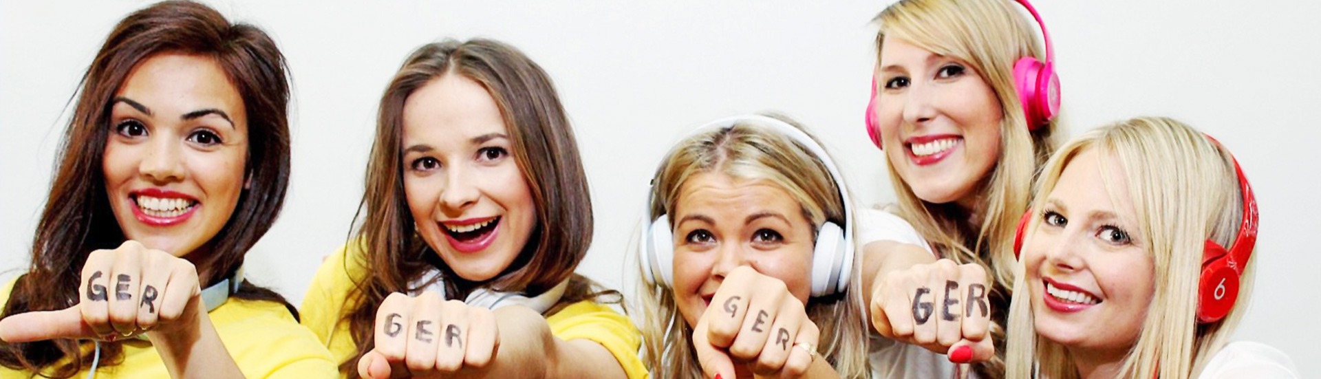 Fünf Frauen im gelben Trikot mit „GER“ auf den Knöcheln strecken die Faust in die Kamera, auffällige Promotion für Deutschland bei Event und Fanaktion