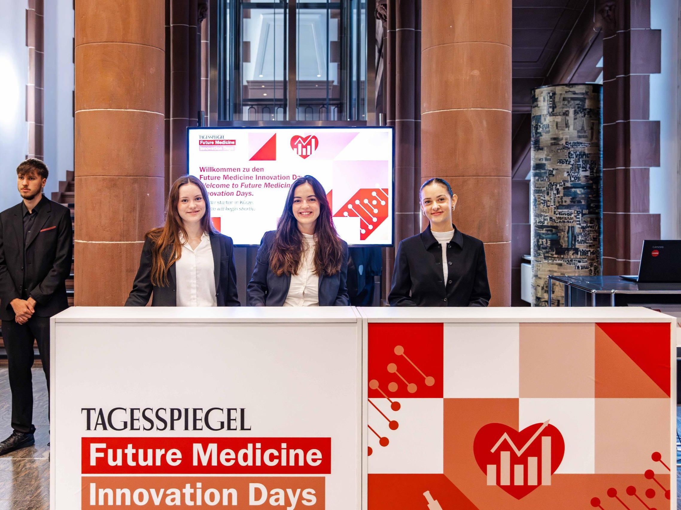 Drei Transferhostessen hinter einem Tresen empfangen freundlich Gäste, professioneller Check-in und Betreuung bei Event und Gästeservice
