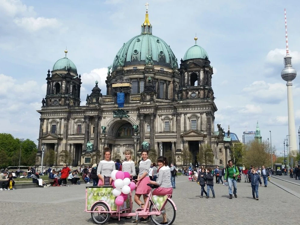 Vier Hostessen vor dem Pergamonmuseum auf der Museumsinsel in Berlin, einheitlich gekleidet in weißen Oberteilen und pinken Röcken bei Promotion Event