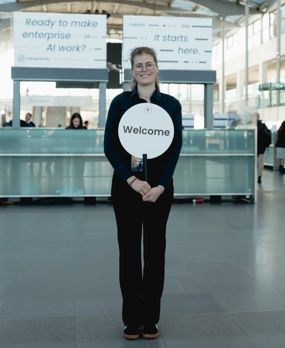 Transferhostess im schwarzen Outfit bereit zur Begrüßung von Gästen, freundlicher Empfangsservice bei Event, Messe und Veranstaltung