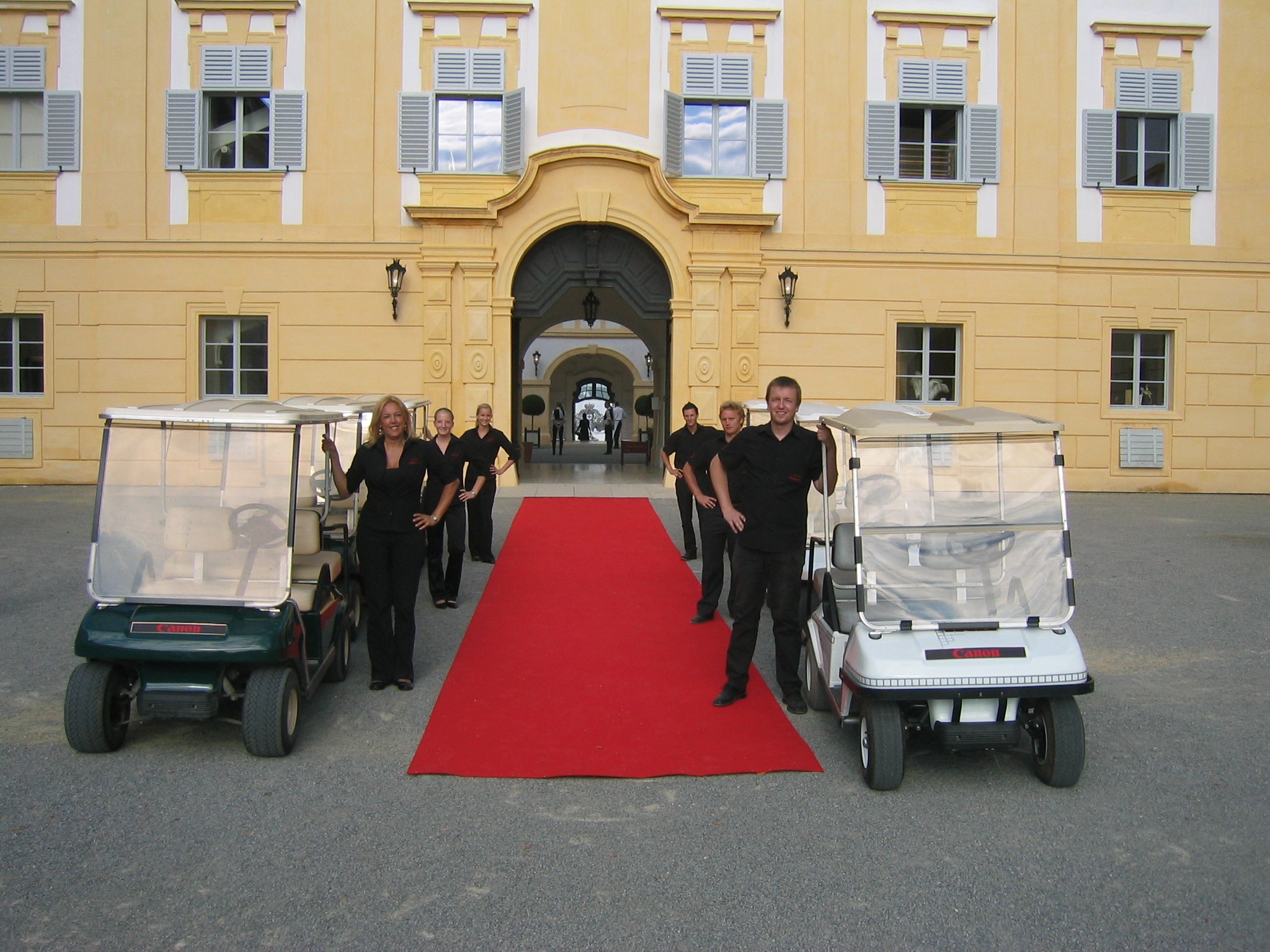 Caddy-Fahrer als Transferhosts und Hostessen warten am roten Teppich, professioneller Shuttle- und VIP-Transportservice bei Event und Gala