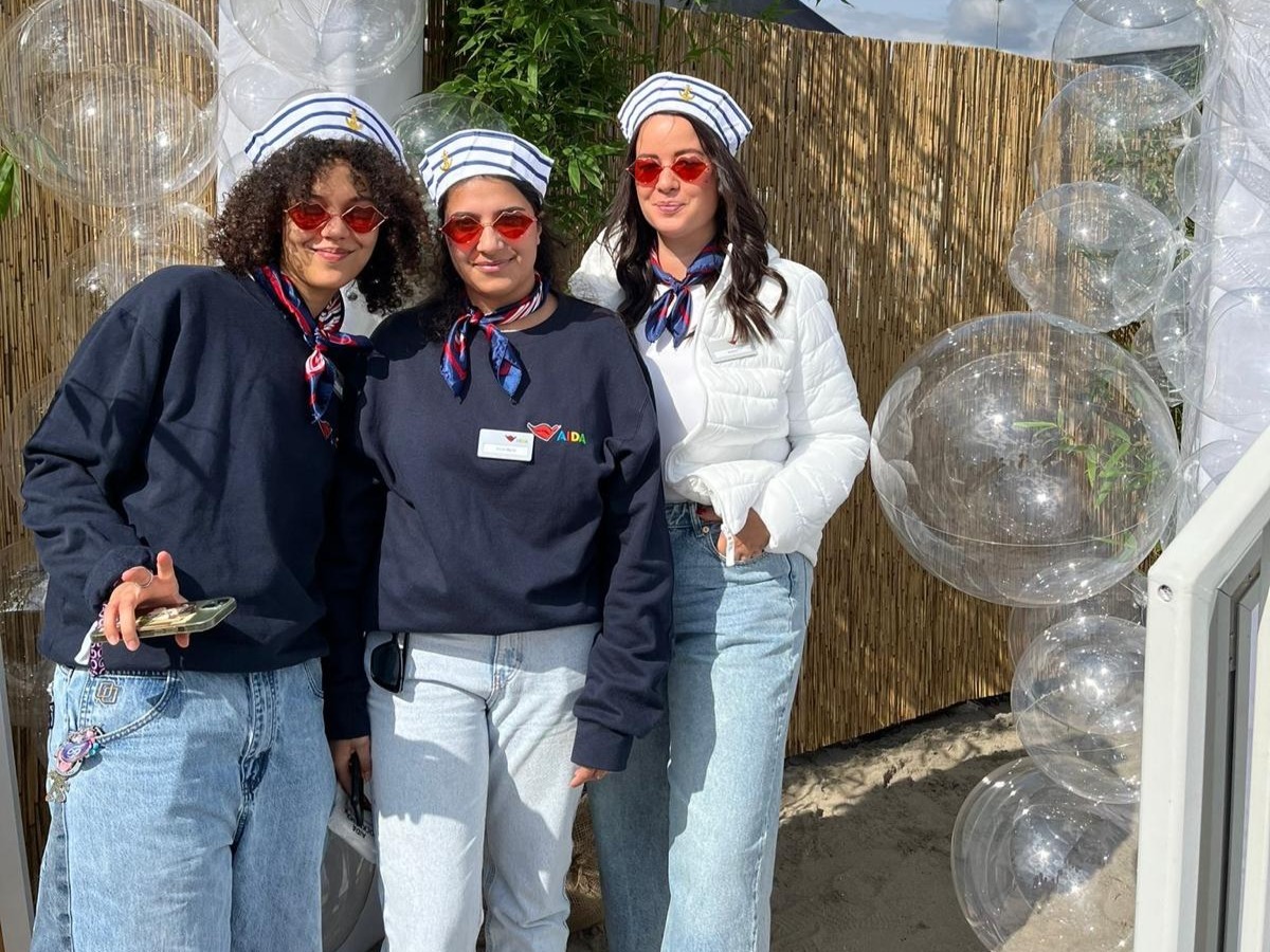 Drei Promoterinnen im maritimen Seemanns-Look mit roten Sonnenbrillen vor einer Fotokulisse in Rostock, kreative Promotion Aktion von cinnamon mit schwebenden Ballons und auffälliger Markeninszenierung