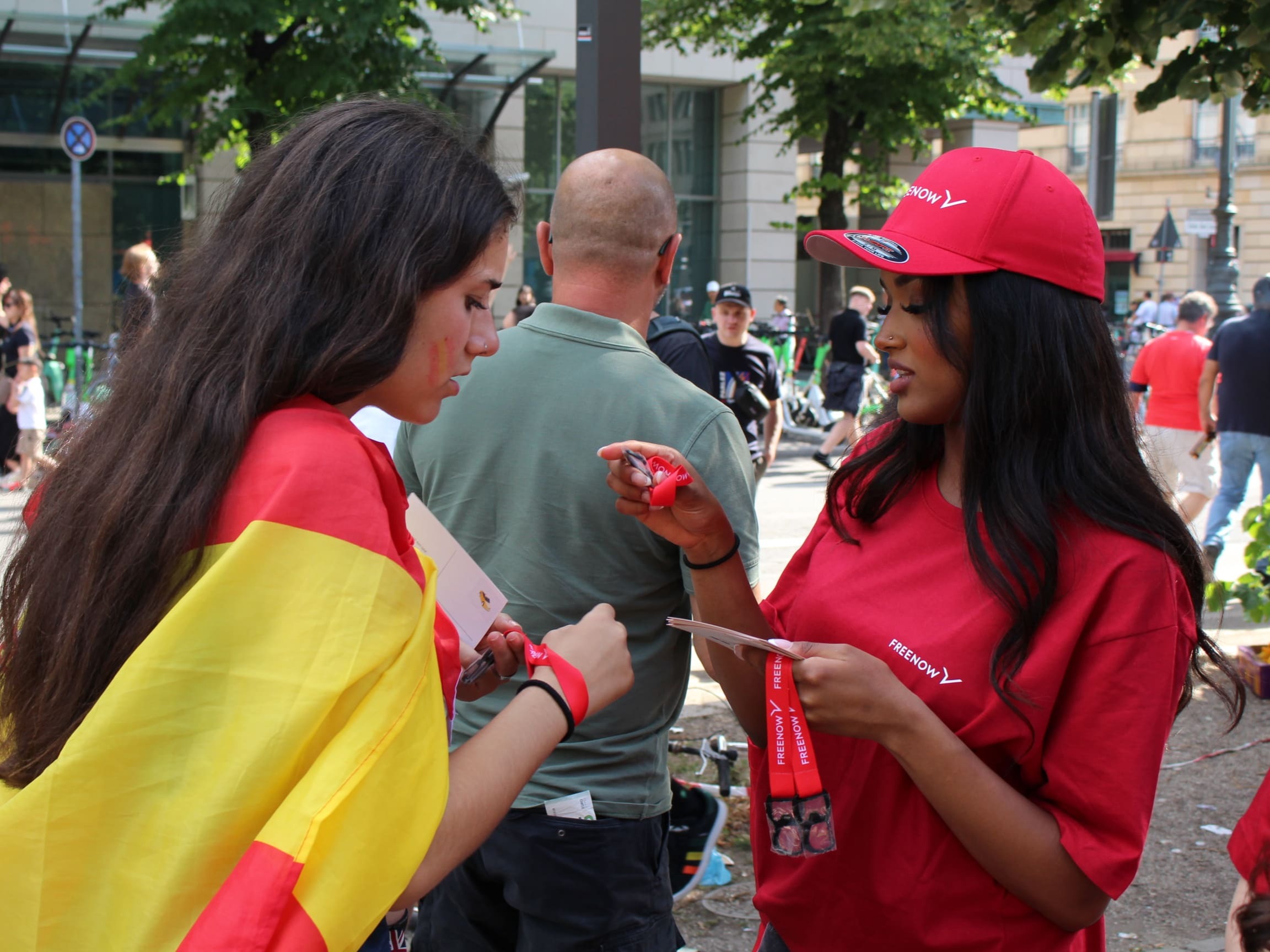 Promoterinnen verteilen Goodies mit Spanien-Flagge bei einer Promotion Aktion, auffällige Markenaktivierung und Eventservice bei internationaler Veranstaltung