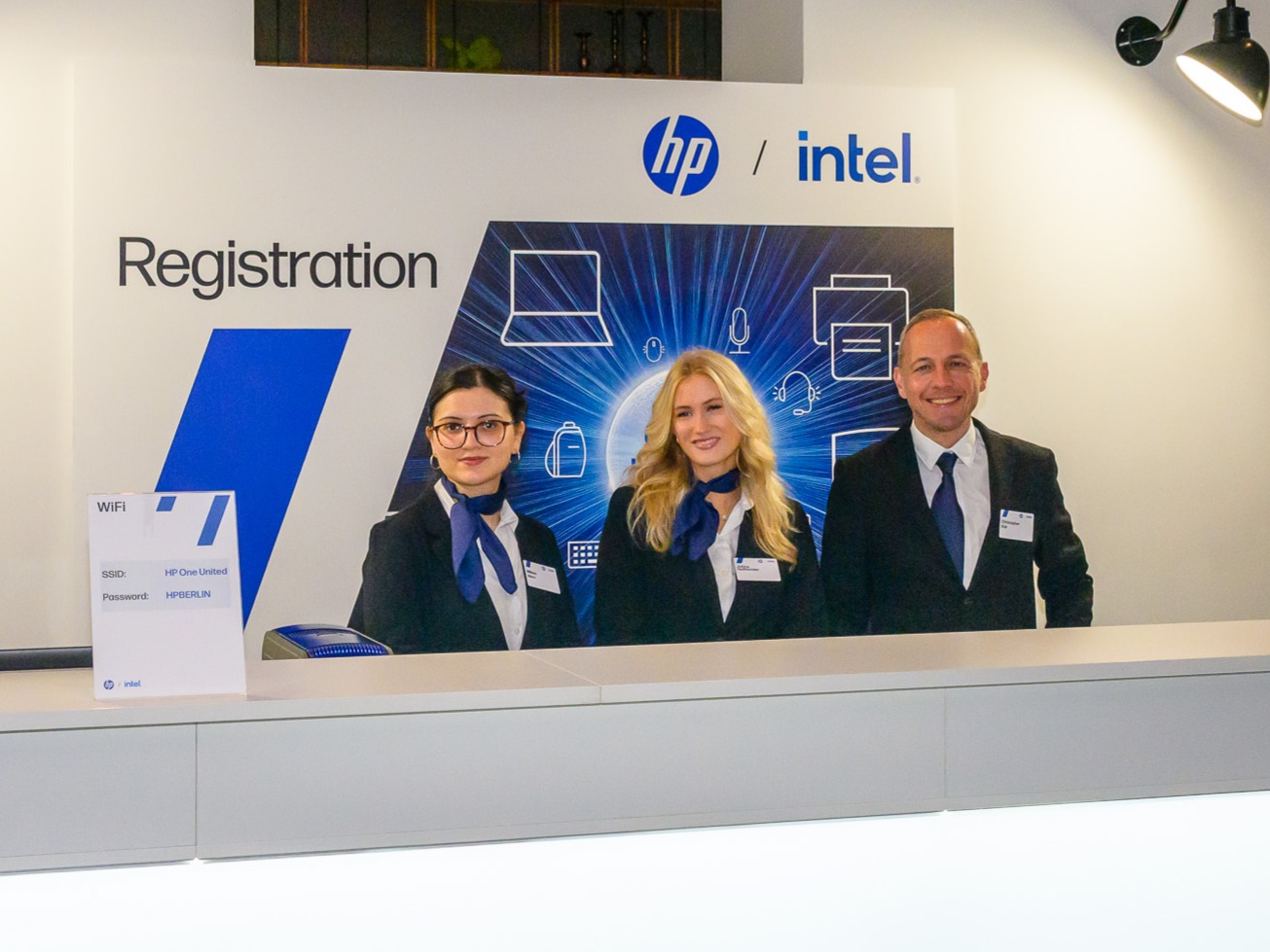 Drei Hosts und Hostessen hinter einem Messetresen in Hannover, professioneller Empfangs- und Promotionservice bei Messe, Event und Markenpräsentation