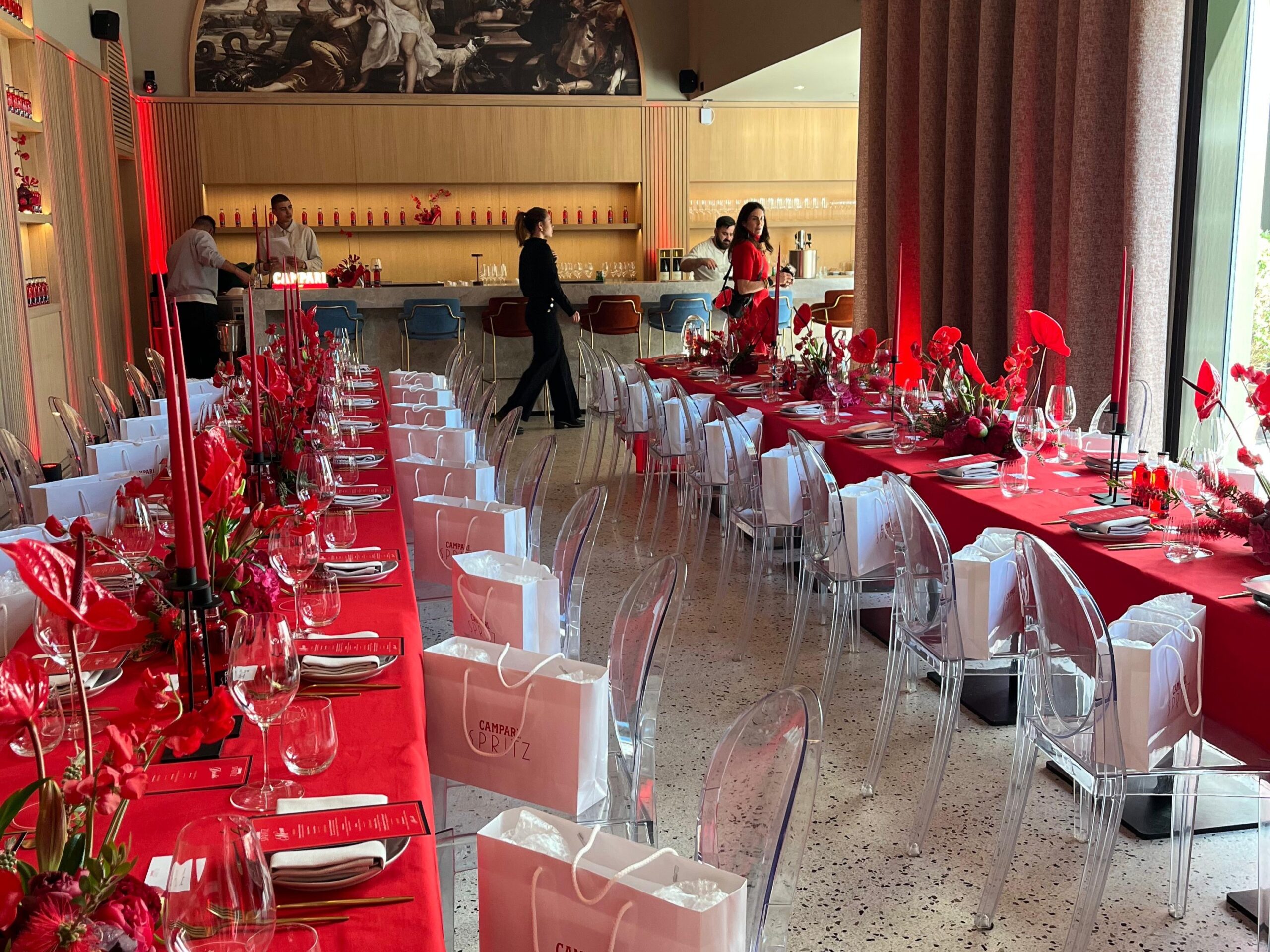 Rot gedeckter Tisch mit vorbereiteten Goodie Bags in transparenten Taschen, professionell organisiert für Event, Gala und Promotion Einsatz