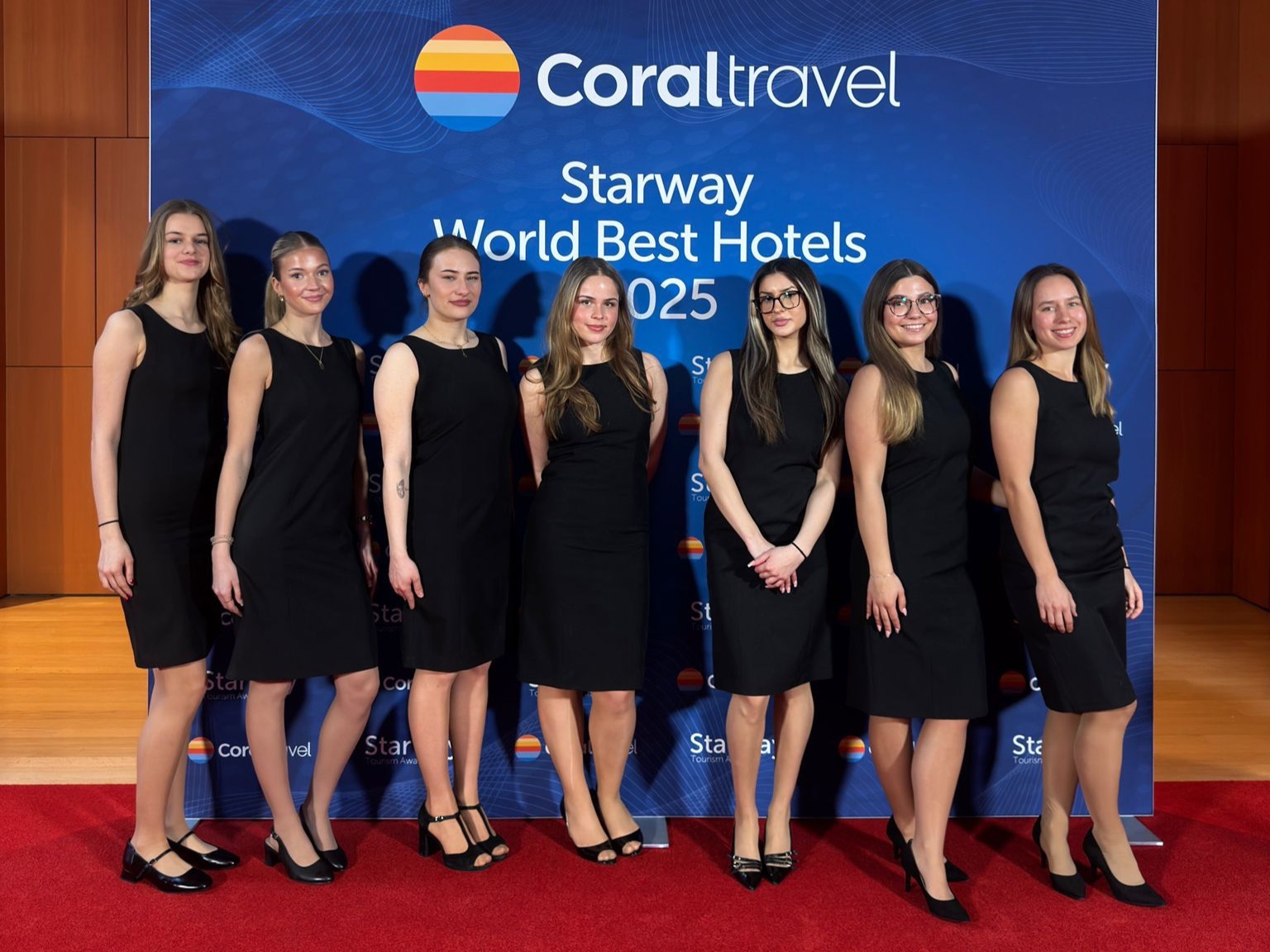Hostessen in kurzen schwarzen Kleidern und High Heels vor einer Unternehmens-Fotowand in Berlin, eleganter Empfang und professioneller Eventauftritt