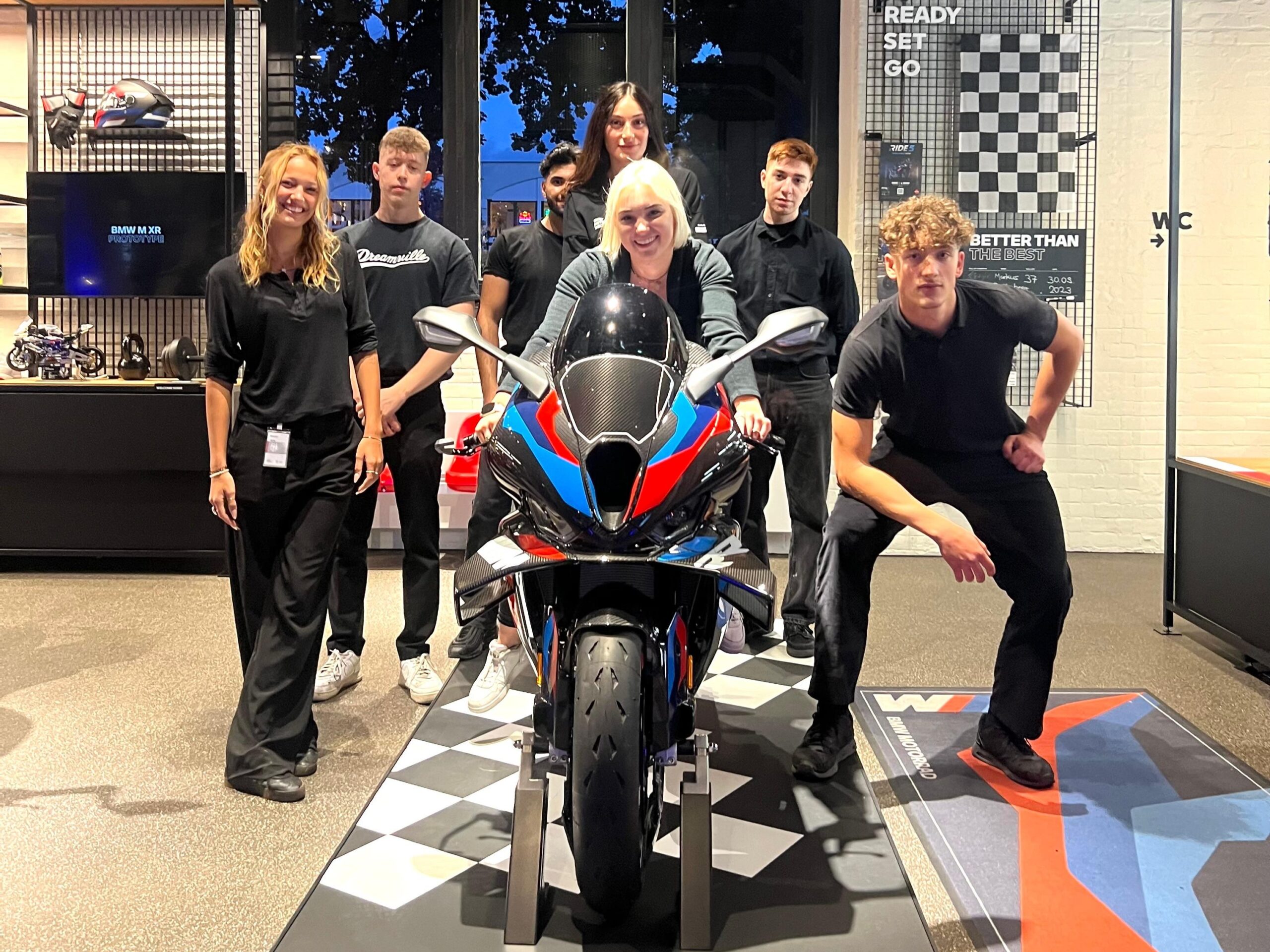 Hosts und Hostessen posieren bei einem BMW Event mit BMW Motorrad, einheitliche schwarze Outfits mit Markenlogo bei Promotion und Markenpräsentation