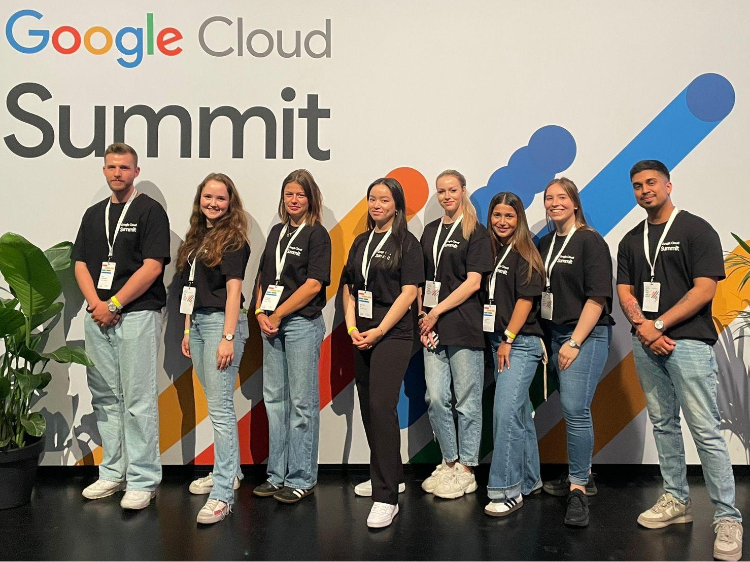 Hosts und Hostessen in Blue Jeans und weißen T-Shirts vor einer Fotowand bei einer Google Messe in Dresden, lächelnder Promotion Einsatz und Markenpräsentation
