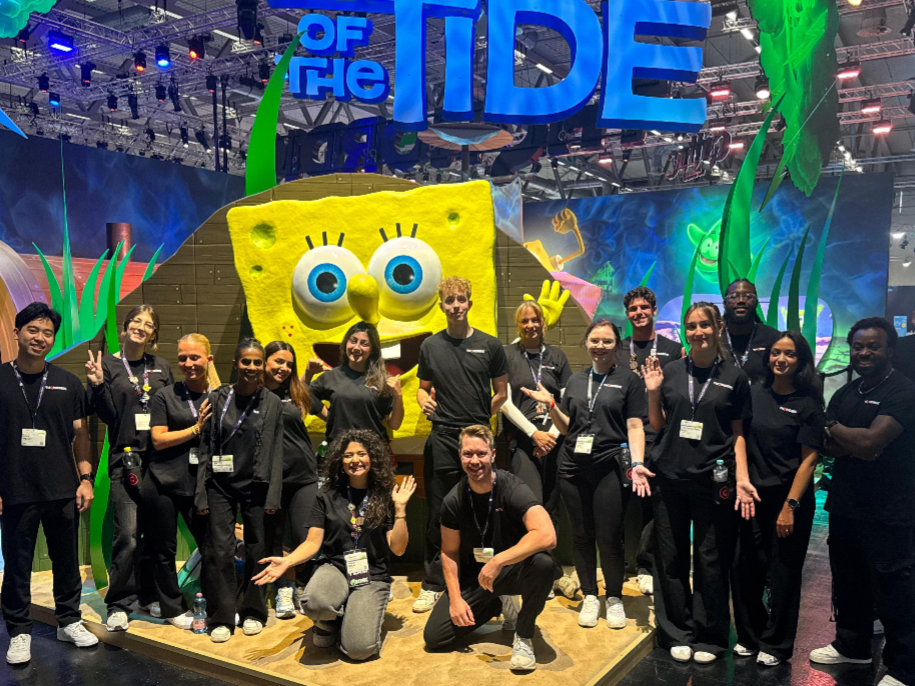 Hosts und Hostessen in schwarzen Outfits vor einer SpongeBob Fotowand auf der gamescom, lächelnder Promotion Einsatz bei Gaming-Event und Markenpräsentation