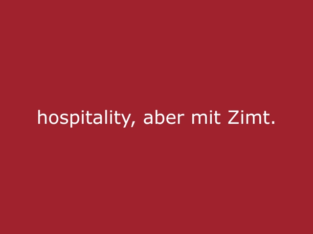 Roter Hintergrund mit beiger Schrift „Hospitality, aber mit Zimt“, kreatives Statement für cinnamon, professionelle Hospitality und Eventpersonal mit besonderer Ausstrahlung
