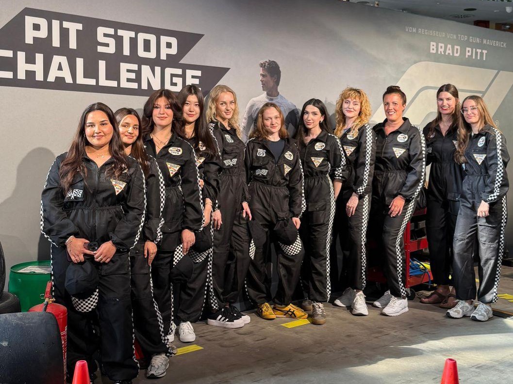 Hostessen im Rennfahrer-Outfit vor einer Fotowand bei der F1 Premiere in Frankfurt, auffällige Promotion und stilvolle Markeninszenierung bei Event und Gala
