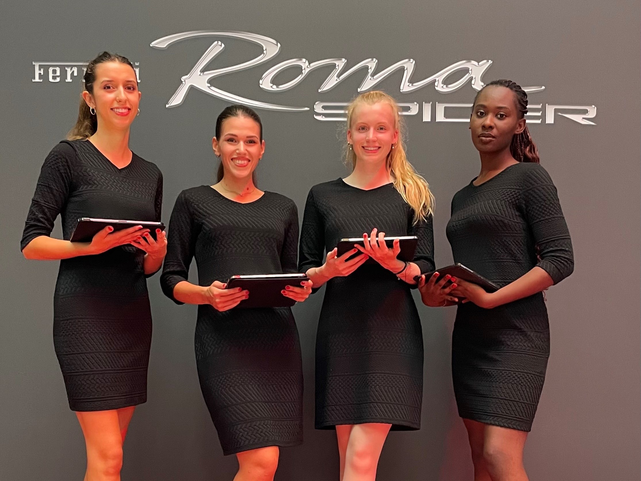 Hostessen in kurzen schwarzen Kleidern mit Klemmbrettern vor einer Fotowand in Dresden, professioneller Empfangsservice bei Event, Messe und Promotion