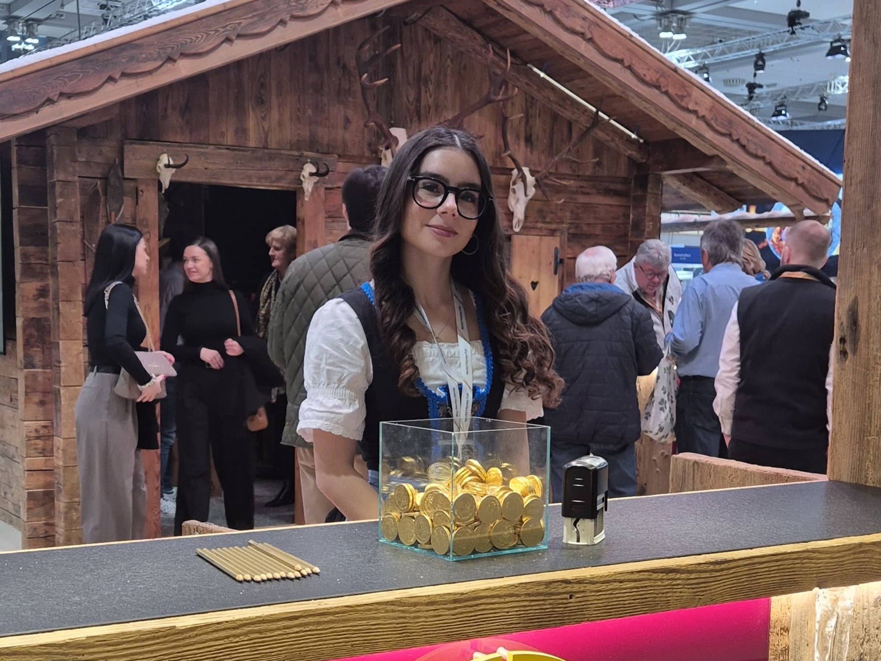 Hostess im Dirndl vor einem Messetresen in Frankfurt, traditionelle Markenrepräsentation und professioneller Empfangsservice bei Messe und Event
