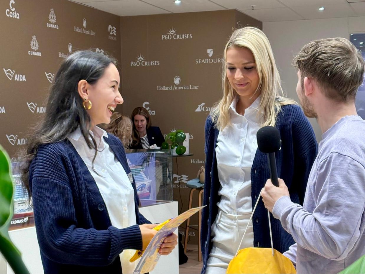 Drei Hostessen auf einer Messe in weißen Hemden und blauen Cardigans, professioneller Empfangs- und Promotionservice bei Event und Markenpräsentation