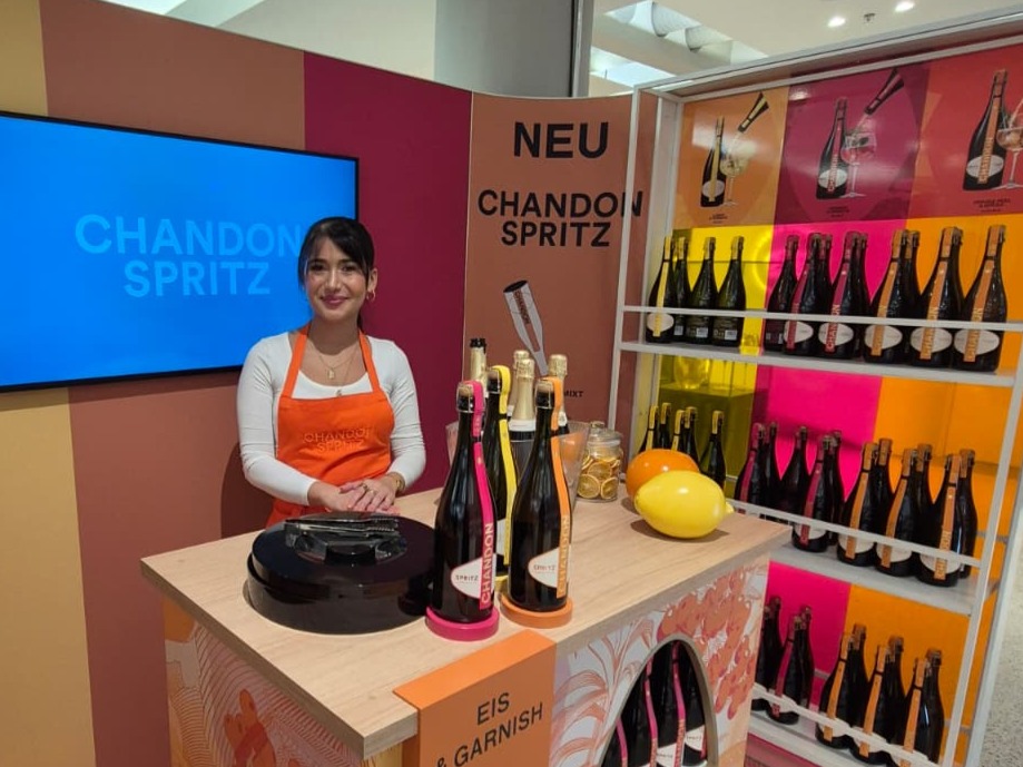 Promotion Hostess in Chandon Schürze hinter einer Bar schenkt Getränke aus, stilvolle Sampling Aktion bei Event und Markenpromotion in Dresden