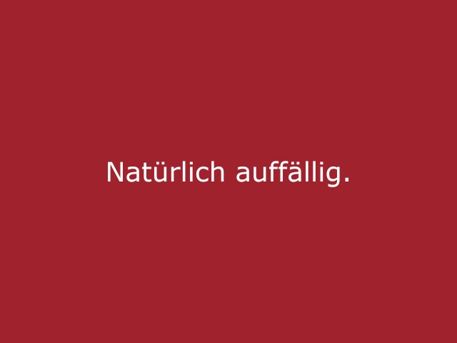 Roter Hintergrund mit beiger Schrift „Natürlich auffällig“, stilvolles Statement für Modelhostessen, Hospitality und präsente Eventauftritte