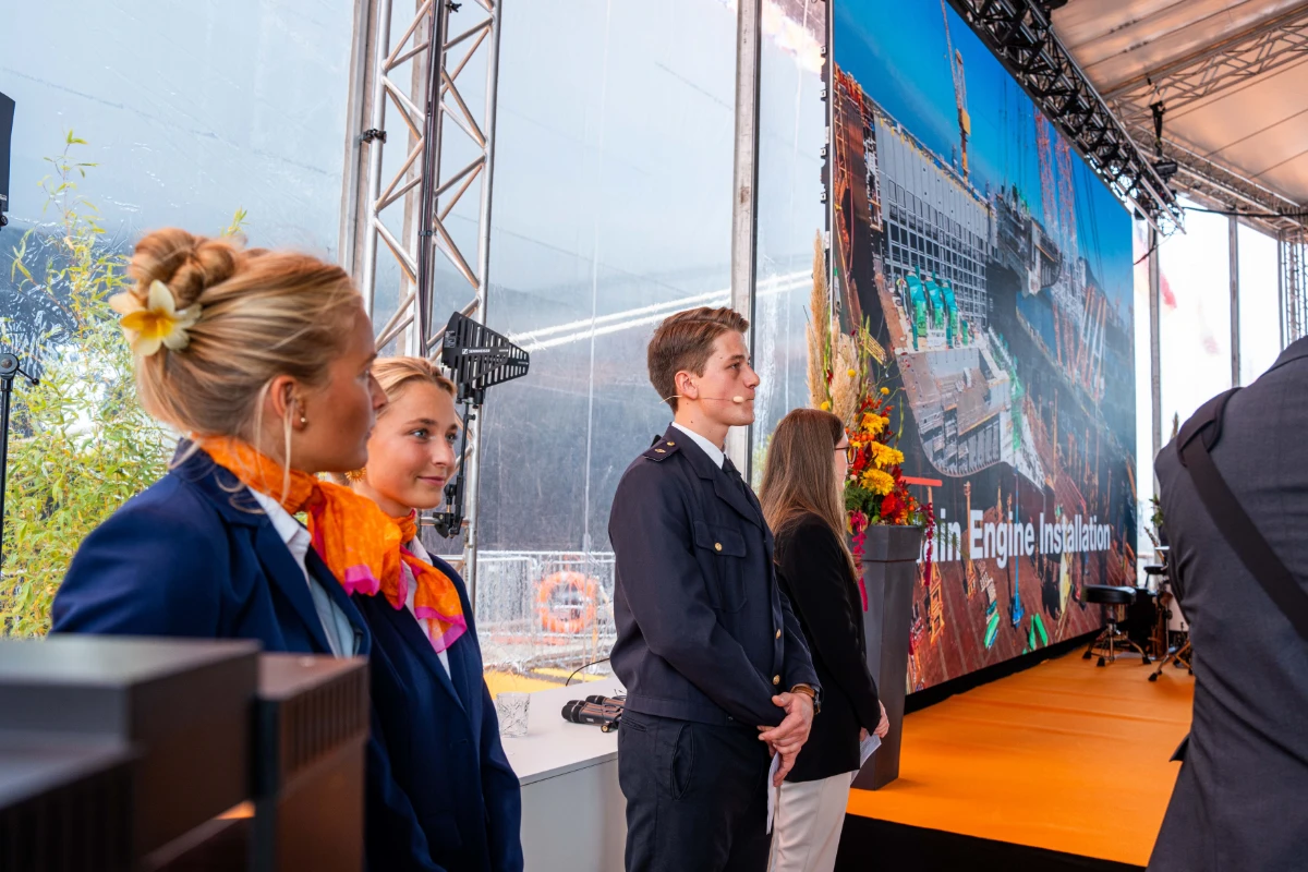 Hostessen und Host in blauen Uniformen an einem Messestand