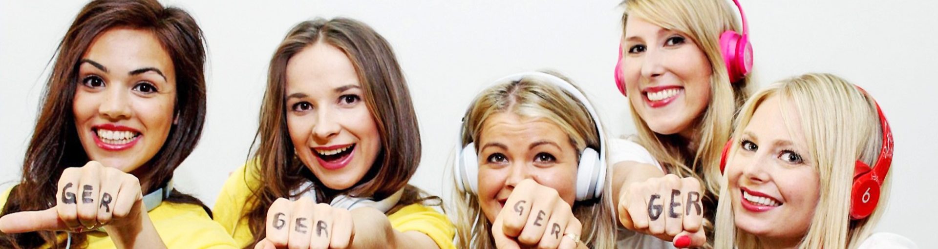 Fünf Frauen im gelben Trikot mit „GER“ auf den Knöcheln strecken die Faust in die Kamera, auffällige Promotion für Deutschland bei Event und Fanaktion
