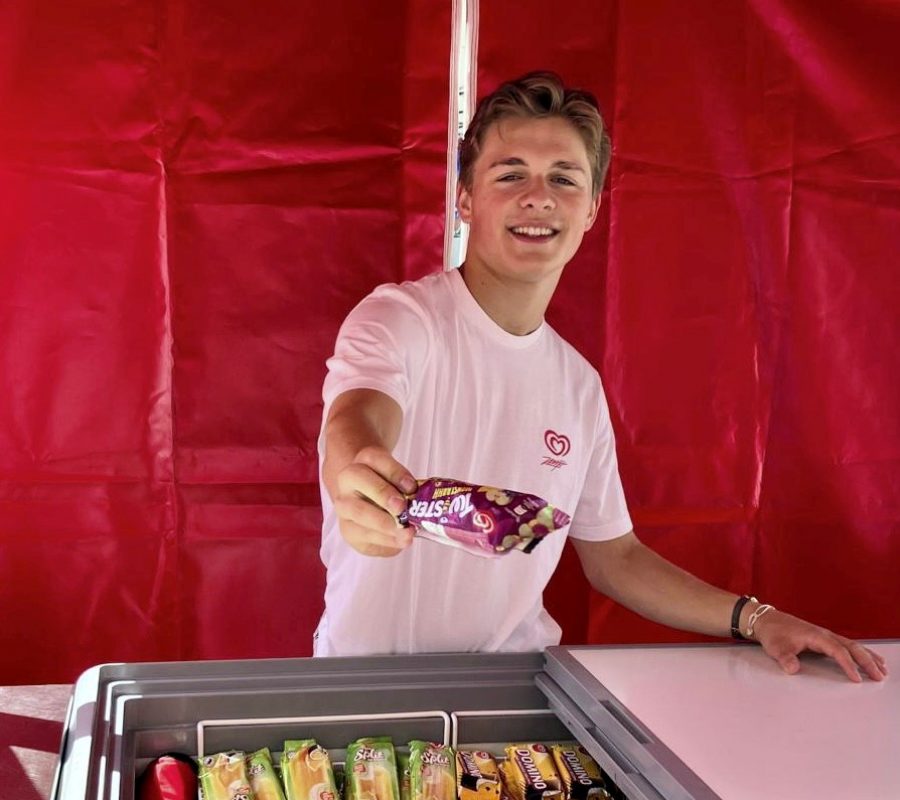 Promoter im roten Oberteil verteilt Eis in einem roten Zelt, Sampling Aktion bei Event, Festival und sommerlicher Markenpromotion