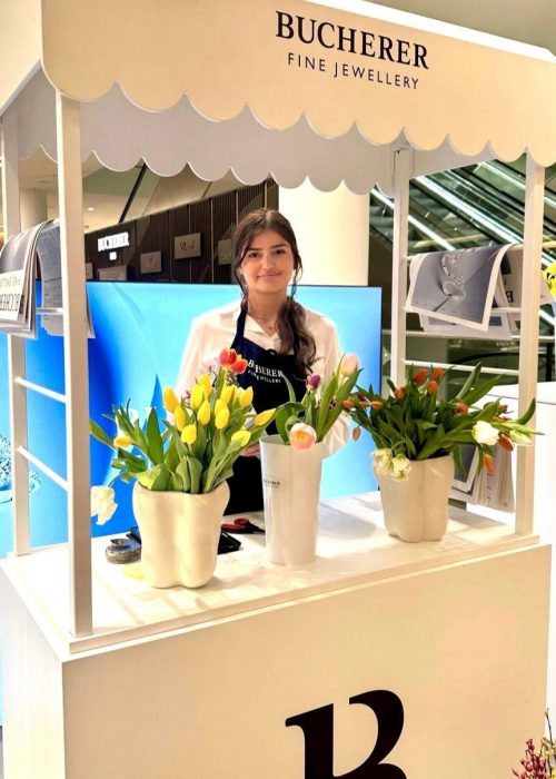 Hostess in weißer Bluse und schwarzer Schürze arbeitet an einem Sampling-Stand, professioneller Promotion Einsatz und Markenaktivierung bei cinnamon Events