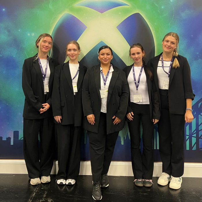 Vier Hostessen in schwarzen Business-Outfits vor einer Xbox Fotowand auf der gamescom in Köln, professioneller Messe- und Promotionservice von cinnamon