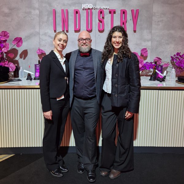 Zwei Hostessen in schwarzen Anzügen mit weißen Blusen vor einer Fotowand bei einer Release Party, eleganter Empfangsservice mit Gästen bei Event und Promotion