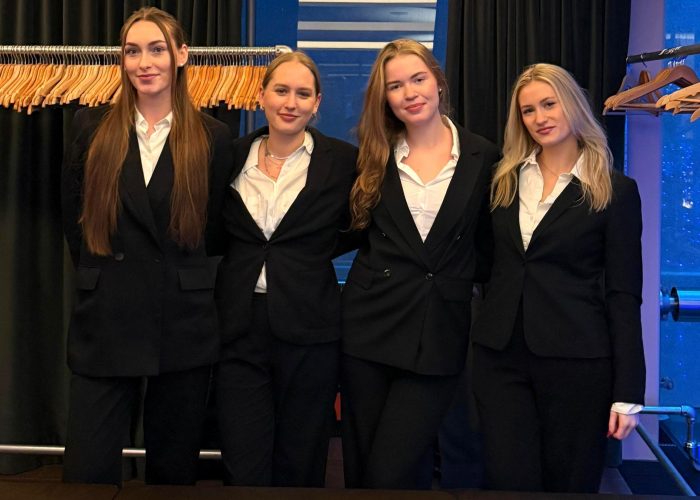 Vier Hostessen im schwarzen Hosenanzug mit weißer Bluse an der Garderobe, professioneller Empfangsservice bei Event, Gala und Veranstaltung